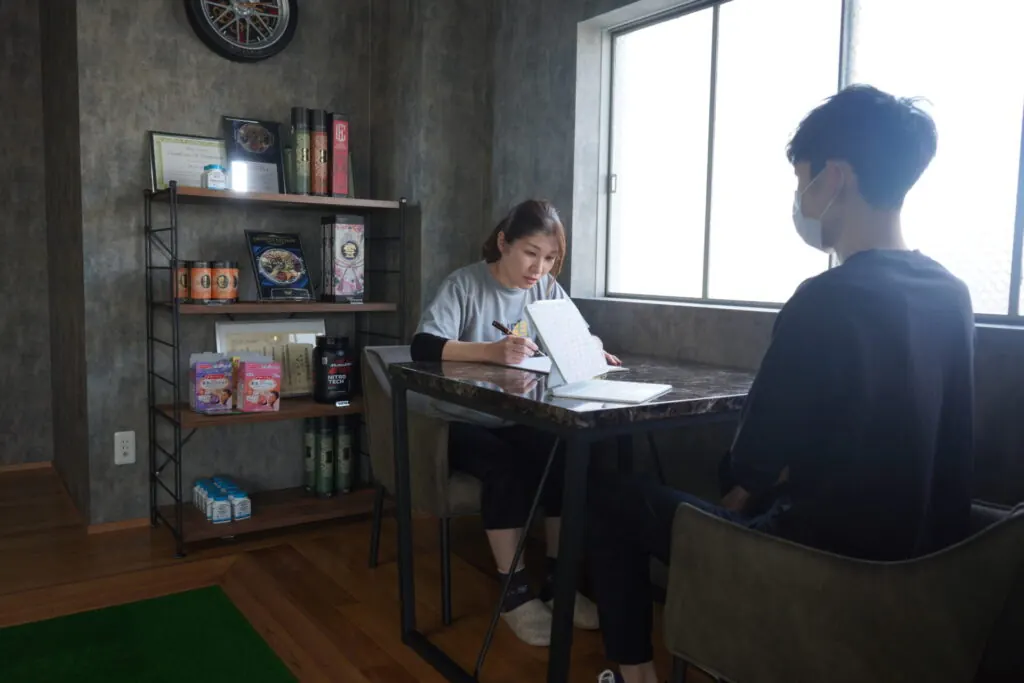 カウンセリングシートに記入するお客様とトレーナー