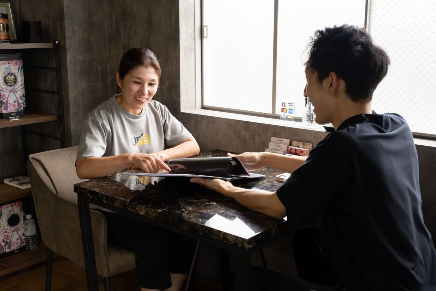 資料を見ながら、トレーナーと笑顔で話すお客様