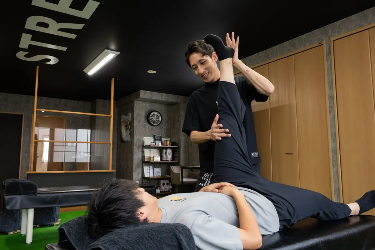 寝たままトレーナーに足を伸ばしてもらうお客様